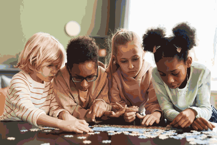 Foto de um grupo de crianças montando quebra-cabeças. Jogos são uma ótima maneira de usar a matemática no dia a dia.