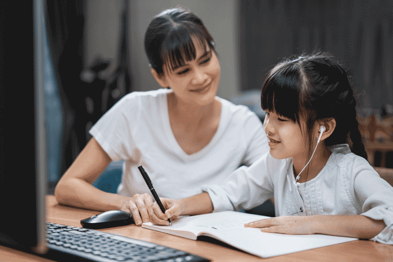 Foto de menina estudando com a mãe usando computador. A tecnologia na educação infantil teve um grande impulso com a pandemia.