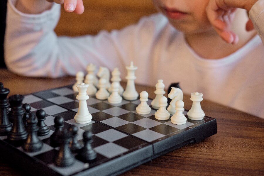 Foto de menino jogando xadrez.