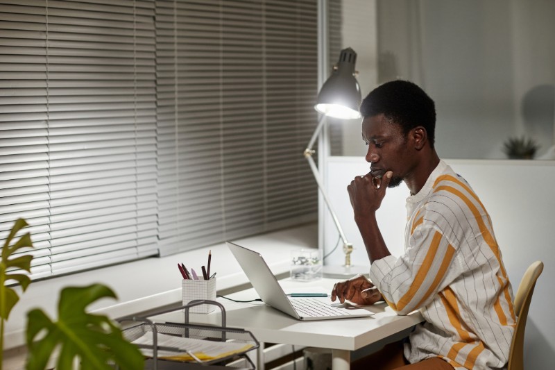 Foto de jovem negro estudando em ambiente bem iluminado e organizado. Ter métodos e hábitos de estudo é muito importante para o sucesso nos estudos.