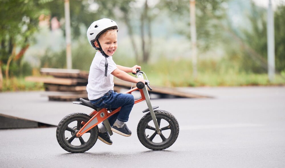 Foto de menino andando de bicicleta, um dos marcos do desenvolvimento infantil.