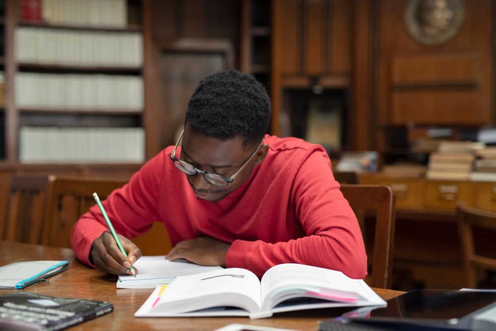 Foto de jovem negro estudando para teste de proficiência em inglês.