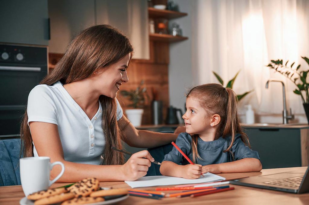 Mãe e menina fazendo exercícios de inglês.