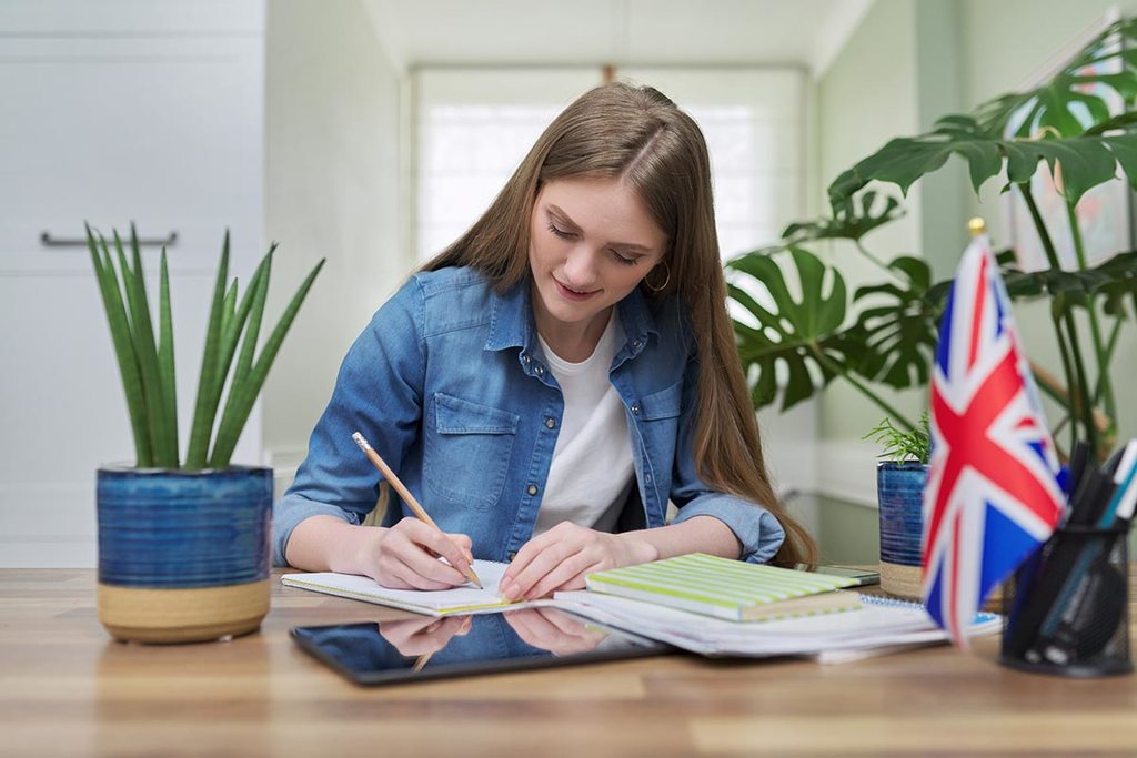 Menina aprendendo inglês em uma mesa.