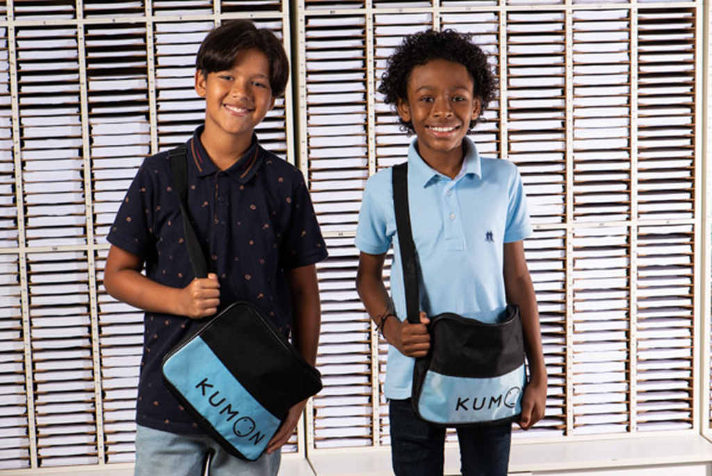 Dois meninos sorridentes com mochilas do Kumon.