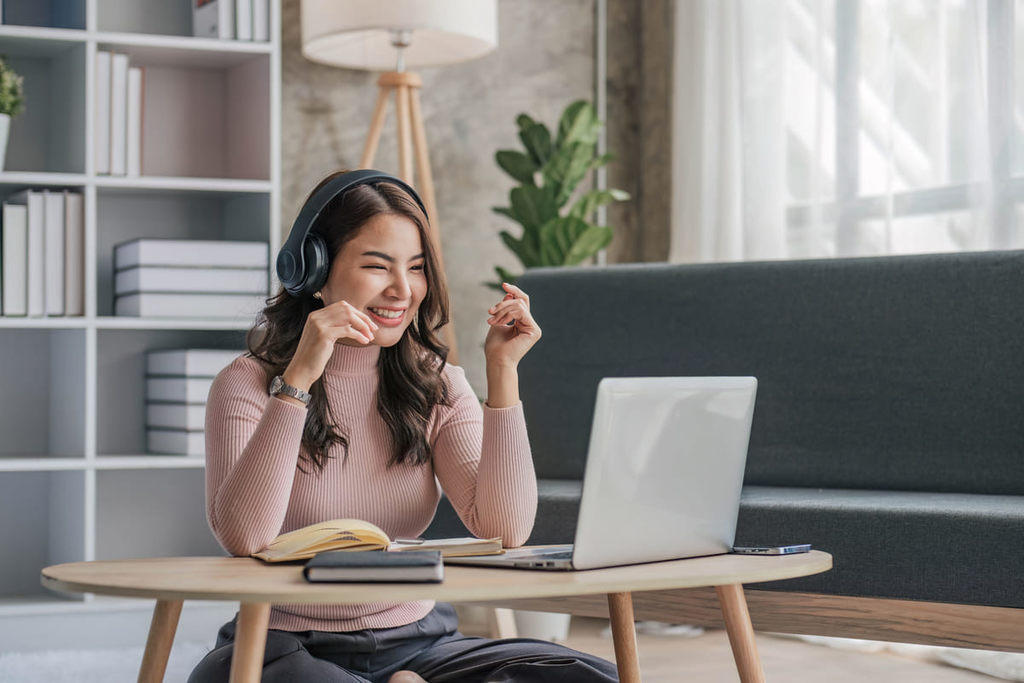 Menina sorridente estudando inglês de fones de ouvido.