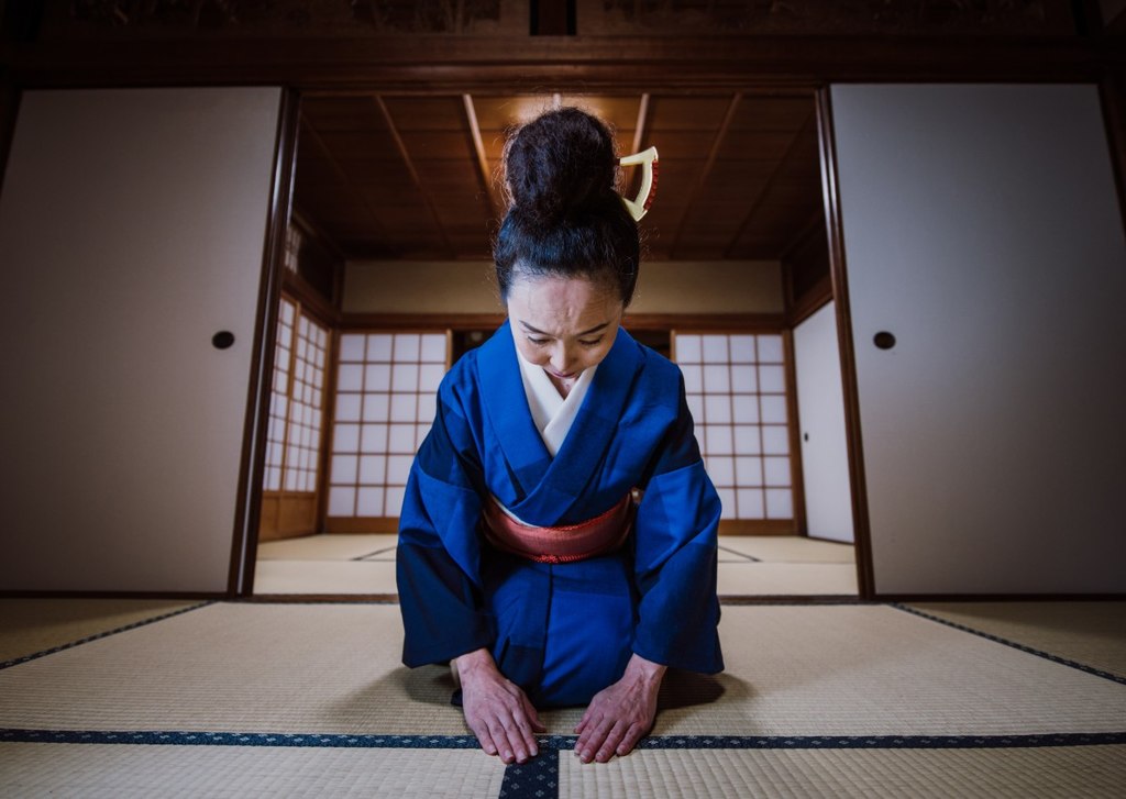 Mulher japonesa sentada em posição solene.