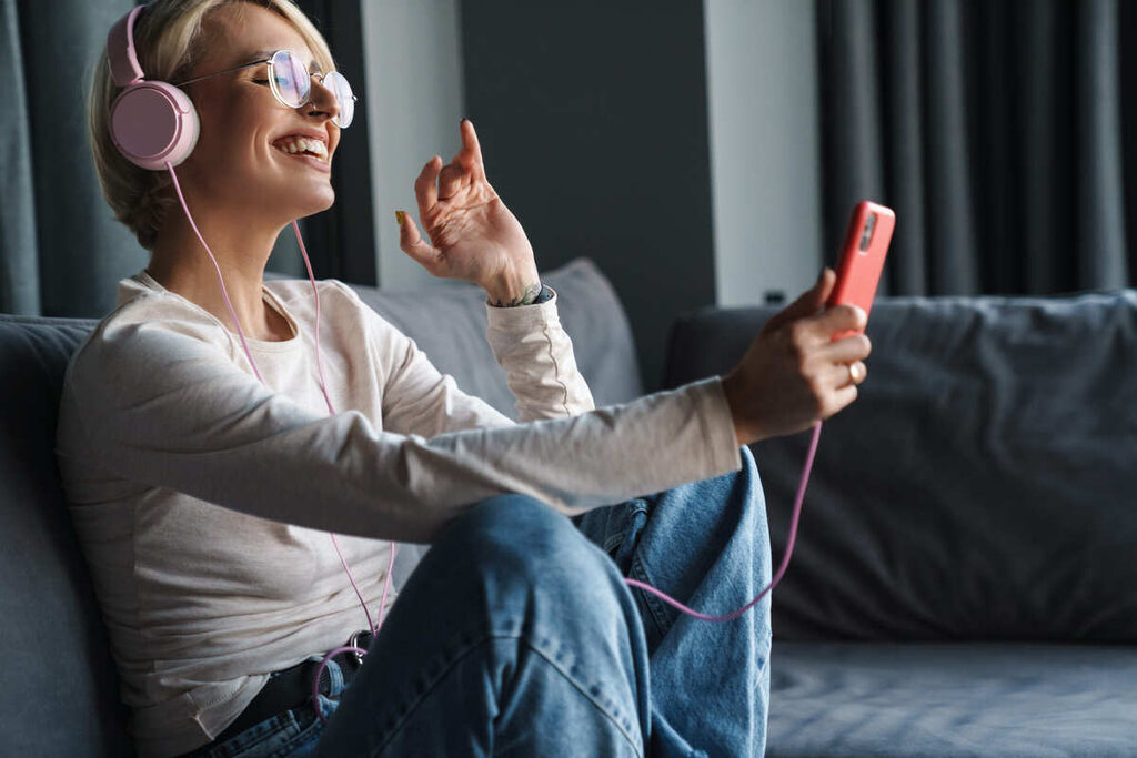 Garota feliz ouvindo música nos fones de ouvido.