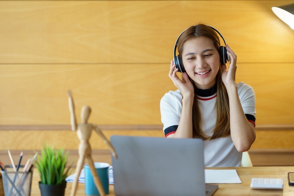 Menina sorrindo ouvindo músicas.