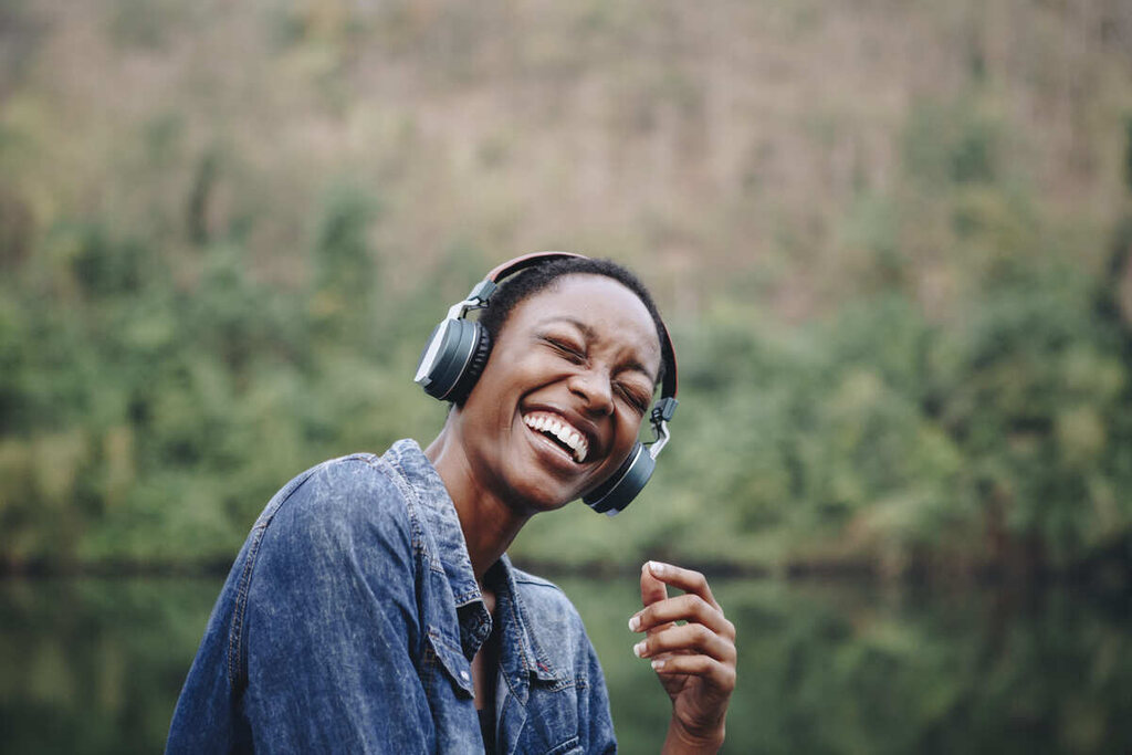 Mulher sorridente escutando músicas em inglês.