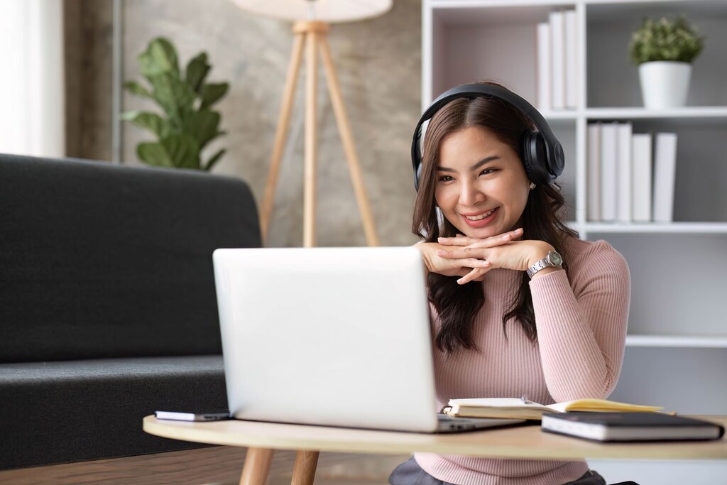 Jovem com fones de ouvido estudando inglês.