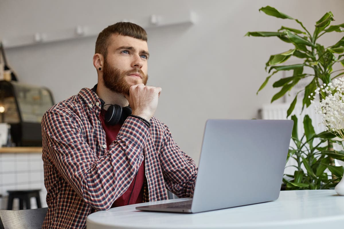 Jovem estudando regras da língua portuguesa em seu notebook.