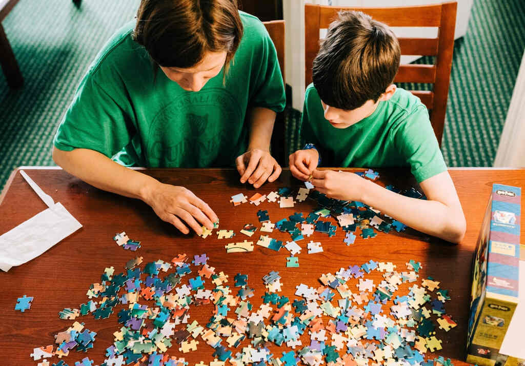 Mãe e filho montando quebra-cabeças juntos.