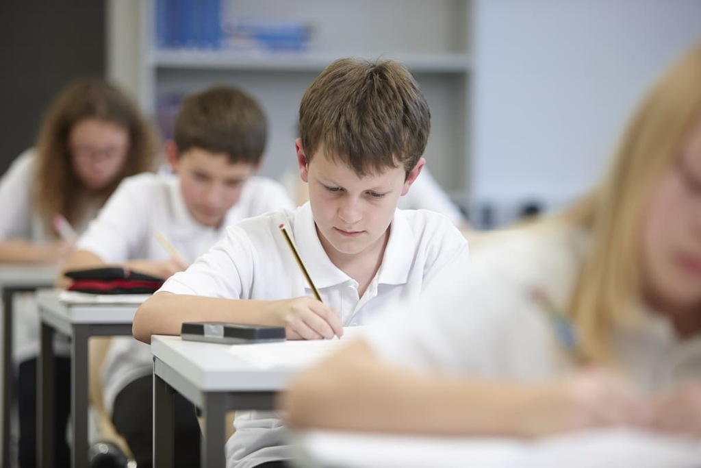 Garoto fazendo seu exame TOEFL Junior na sala.