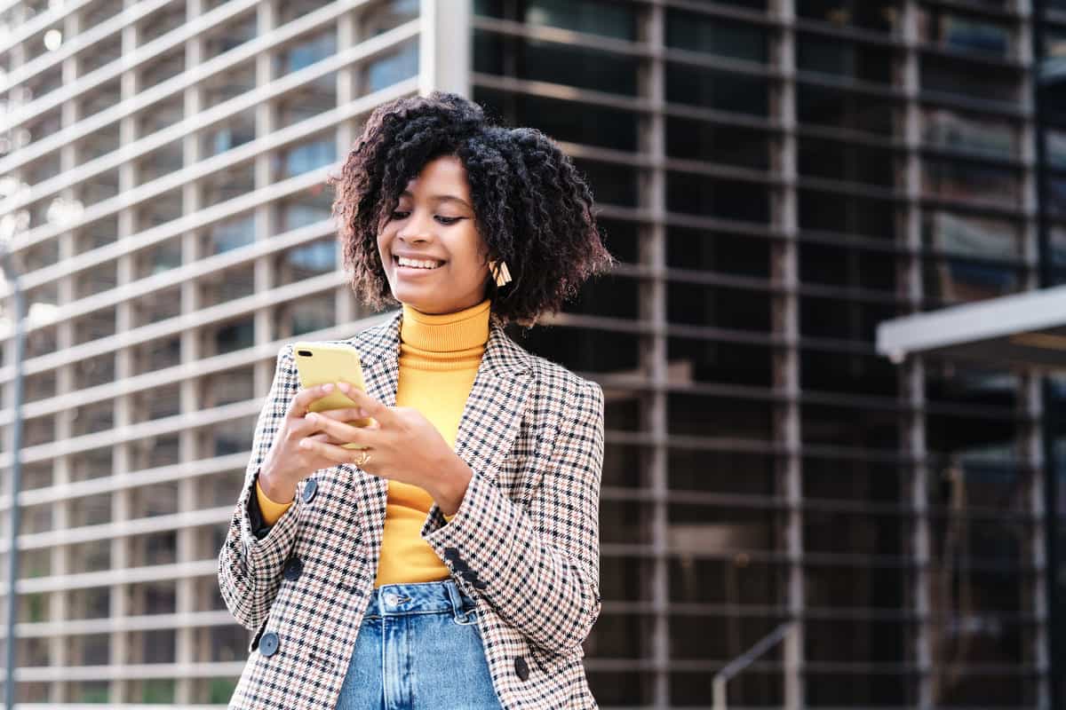 Mulher de negócios usando seu telefone ao ar livre.