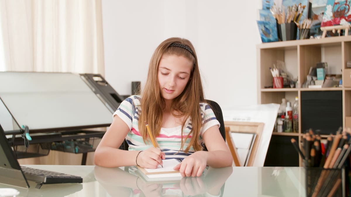 Jovem estudante escrevendo exercícios de matemática no caderno.