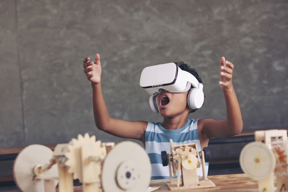 Menino usando óculos de realidade virtual em sala de aula.