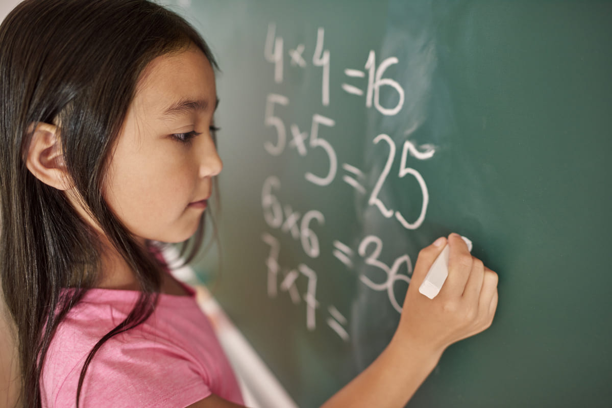 Menina tentando resolver equação matemática.