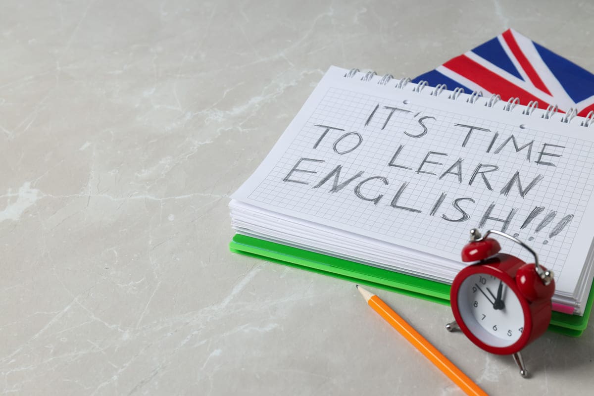 Frase em caderno: It’s time to learn English!