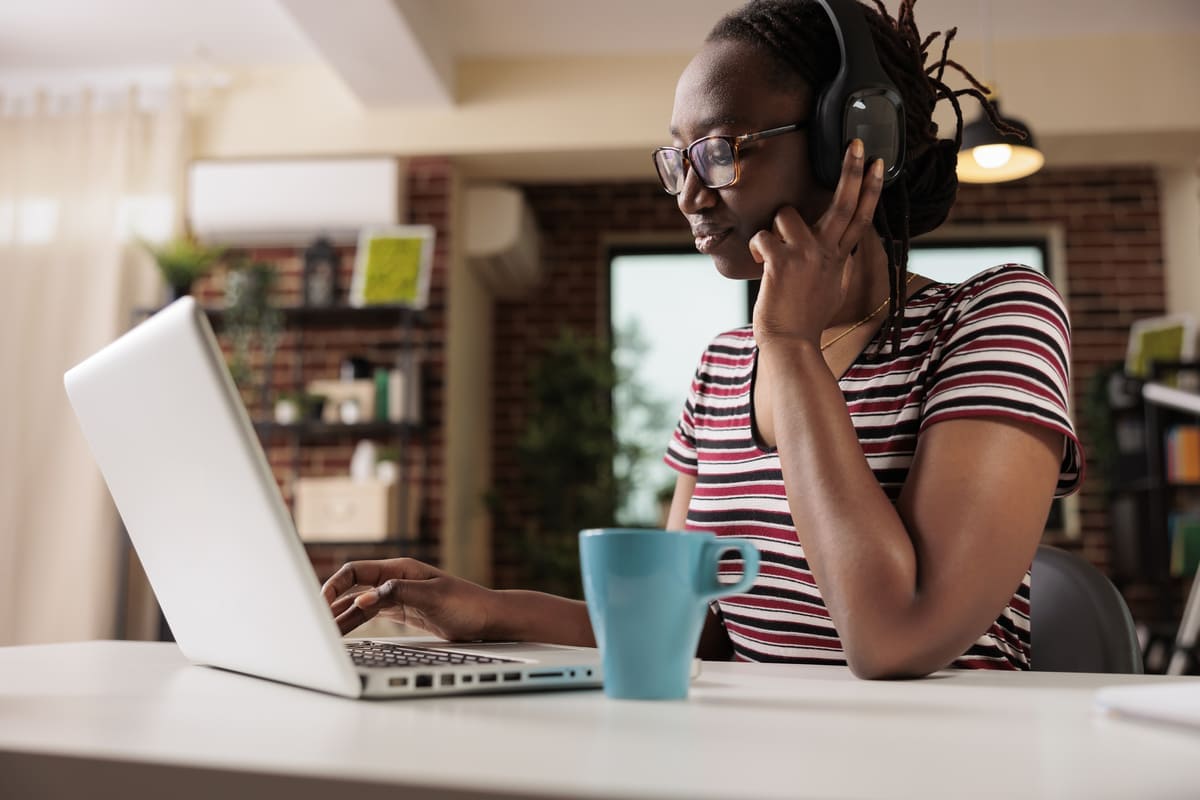 Mulher em fones de ouvido assistindo séries em inglês no laptop