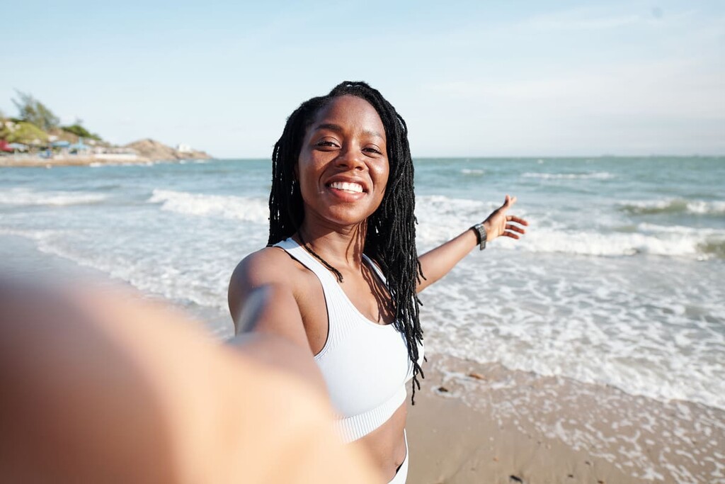 Mulher tirando uma selfie na praia.