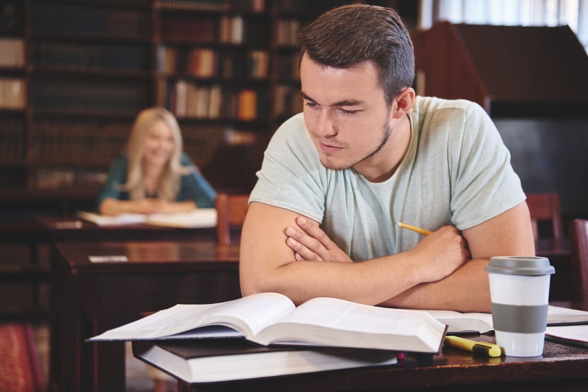 Jovem aprendendo algo novo na biblioteca.