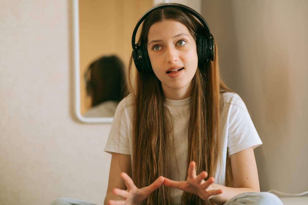 Estudante de fone treinando pronúncia em inglês.