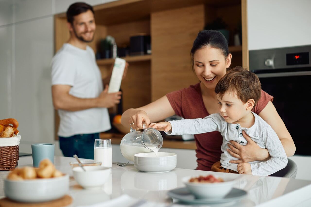 Mãe e filho felizes desfrutando do café da manhã em casa.