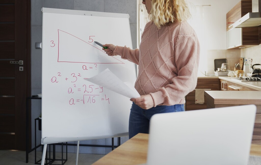 Jovem professora explica tarefas de matemática.