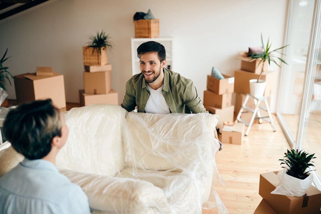 Casal feliz carregando móveis para seu novo apartamento.