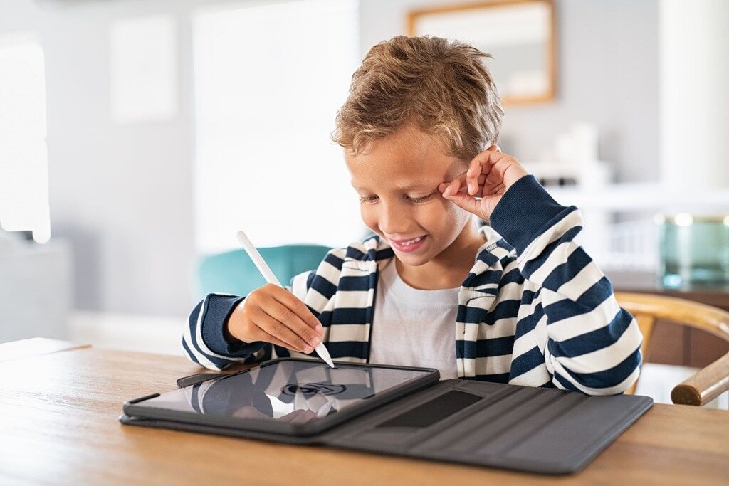 Menino estudando com tablet.