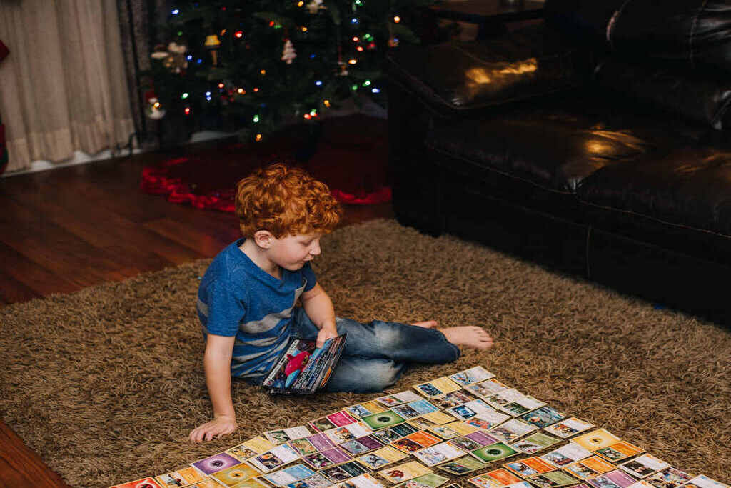 Um garotinho jogando cartas Pokémon. 