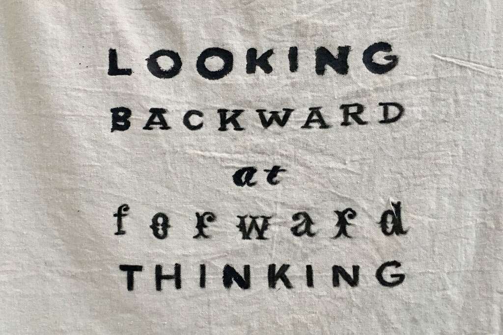 Pano com a frase Looking backward at forward thinking.