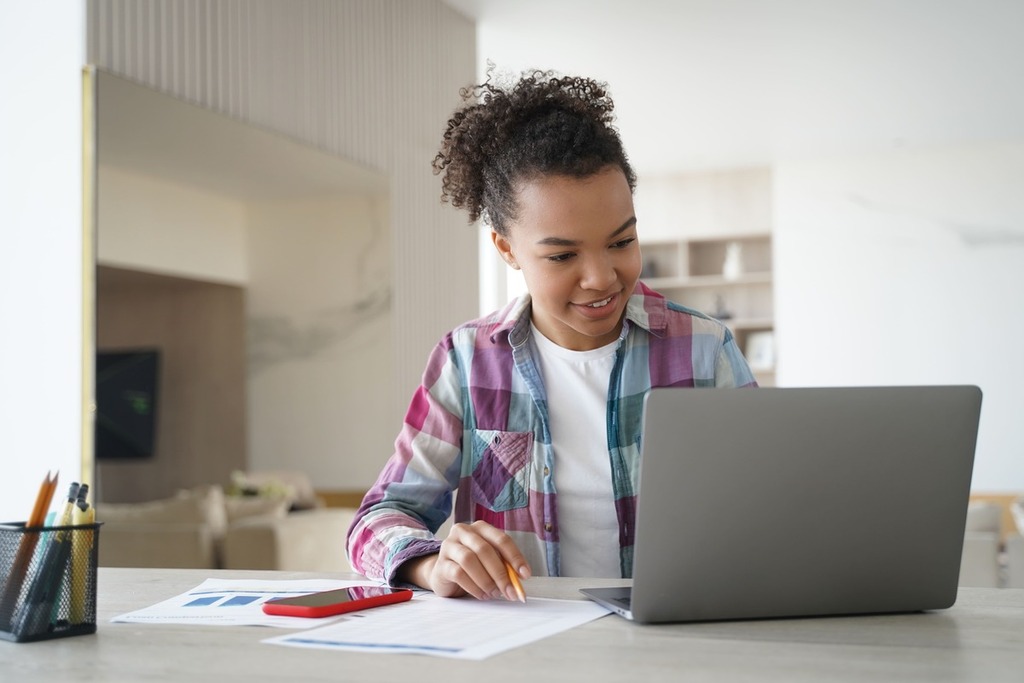 Aluna estudando concordância verbal no computador.