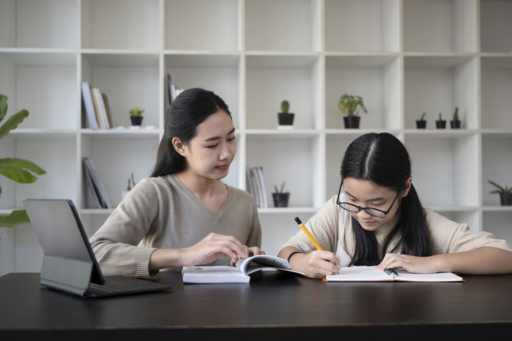 Estudante fazendo tarefas e lendo livros para aprender japonês.