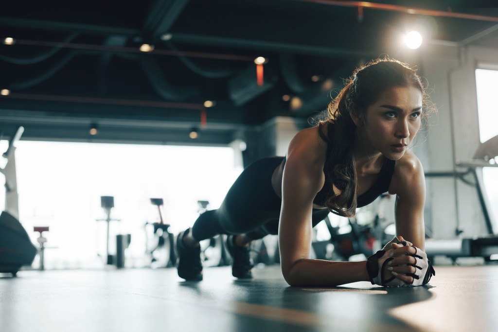 Mulher fazendo plank e pensando em como usar o vocabulário de academia em inglês