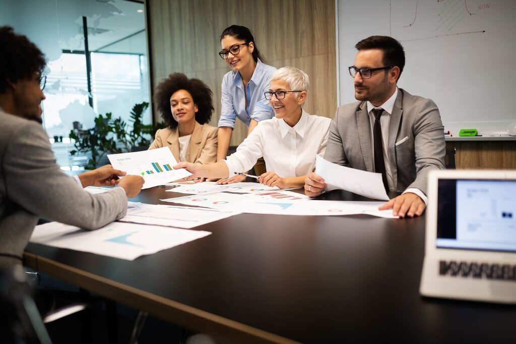 Equipe de negócios discutindo sobre nomes de reuniões corporativas em inglês