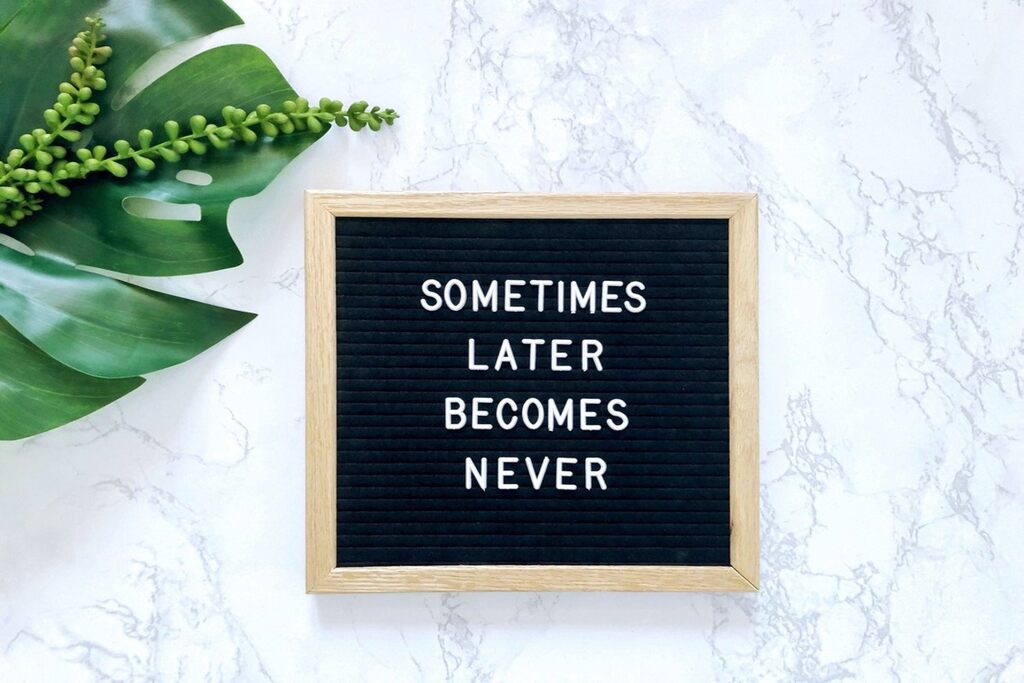 Quadro com a frase: Sometimes later becomes never exemplo de adverbs of frequency