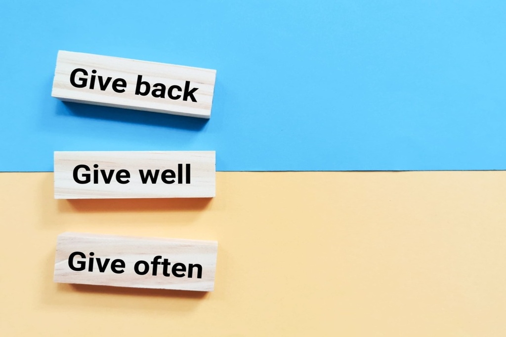 Madeiras com a frase: Give back. Give well. Give often exemplo de adverbs of frequency