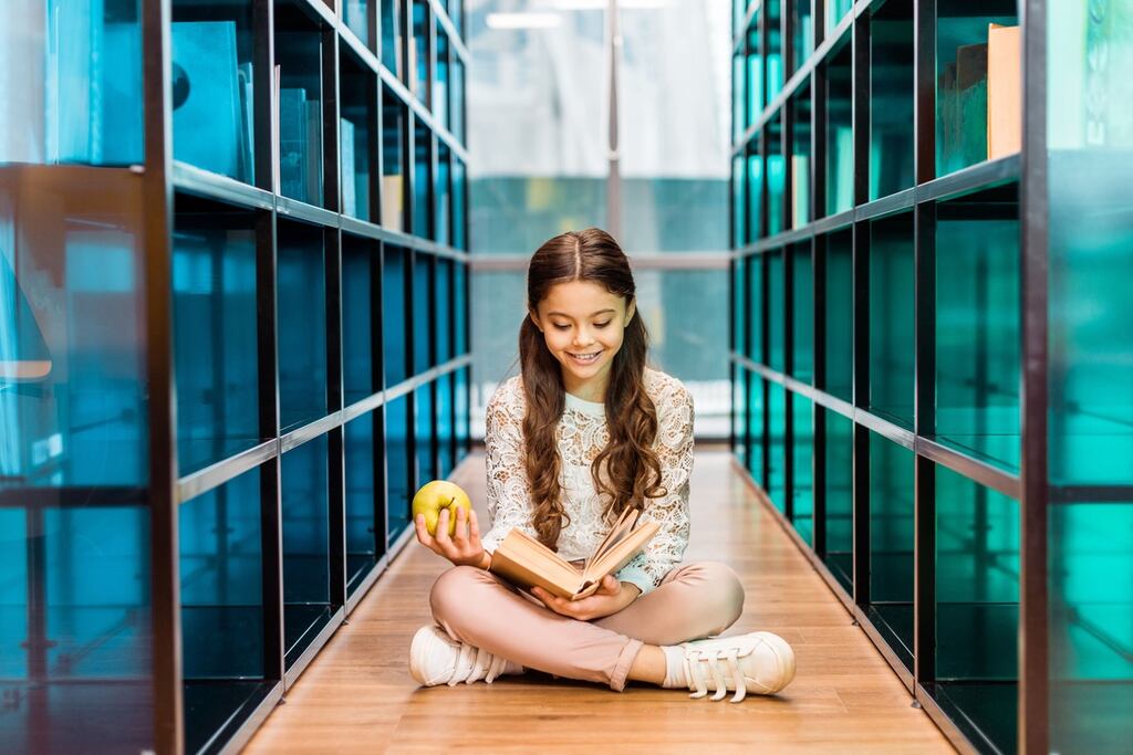 Estudante na biblioteca aprendendo a diferença entre verbo transitivo e intransitivo