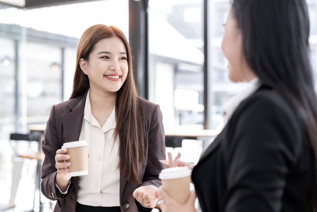 Duas colegas de trabalho fazendo saudações em japonês.