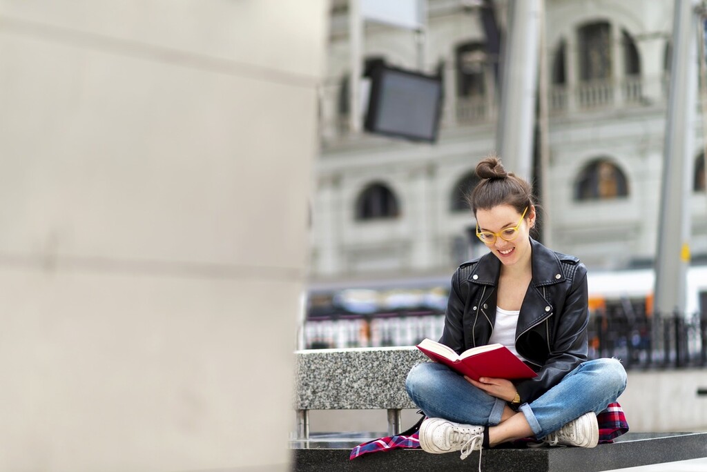 Mulher lendo na rua livros em inglês para iniciantes