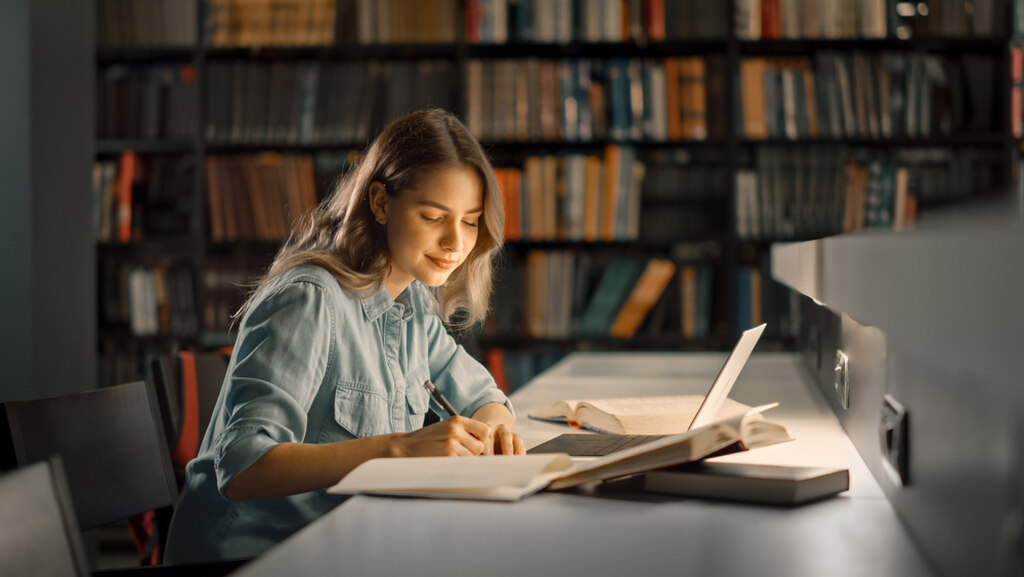 mulher estudando em biblioteca sobre como melhorar o vocabulário em inglês