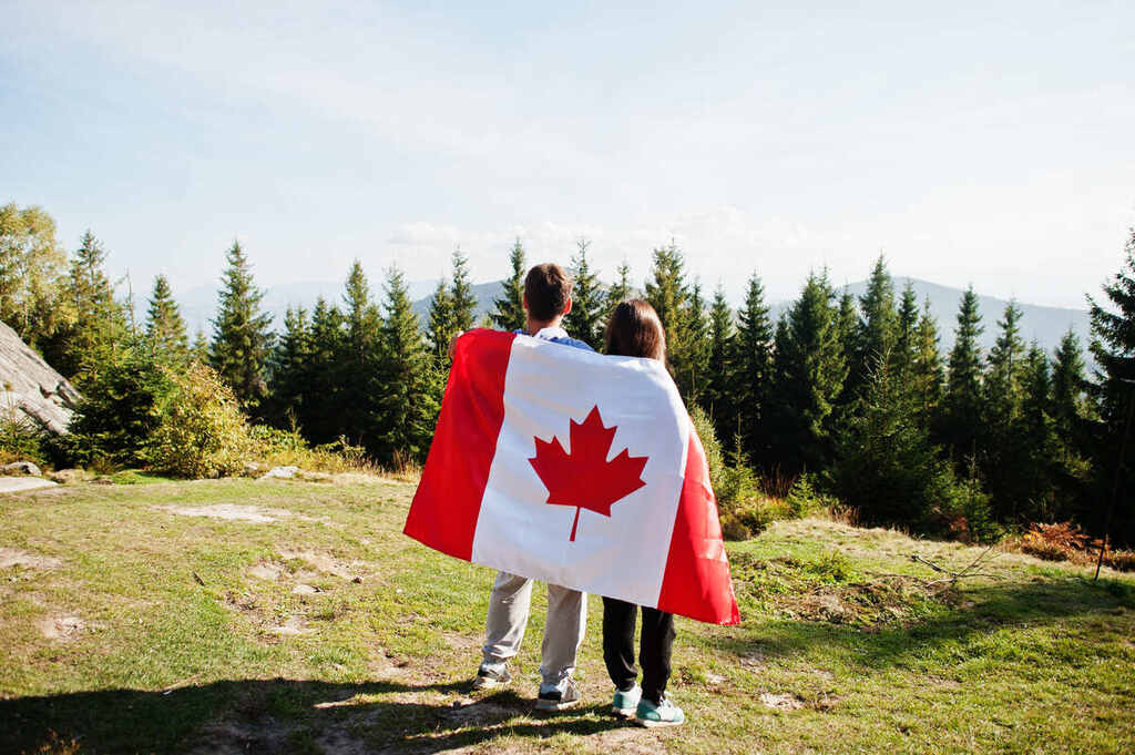 pessoas segurando a bandeira do Canadá representando o inglês canadense