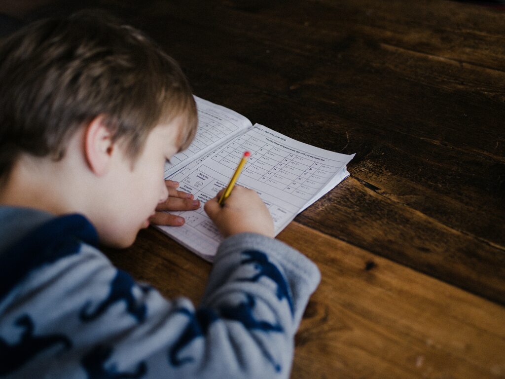 criança escrevendo em caderno de depois de saber sobre seu estilo de aprendizagem