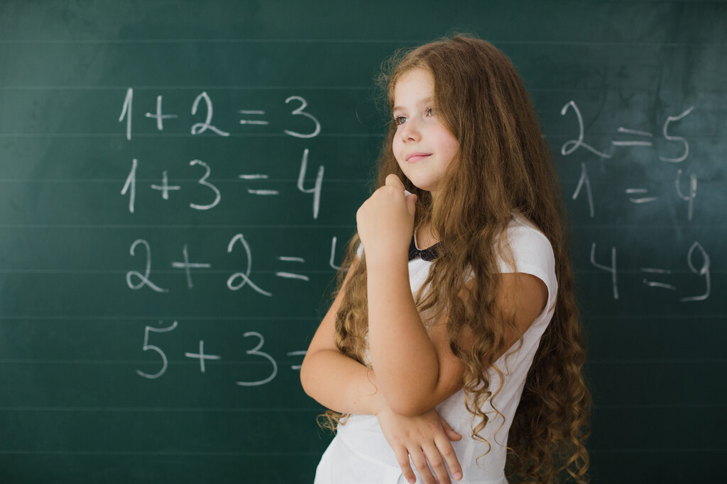 aluna em frente a quadro representando por que estudar matemática