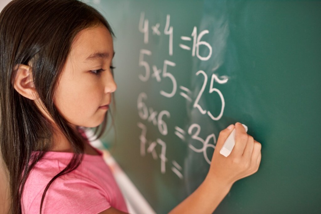 aluna escrevendo cálculos no quadro depois de entender por que estudar matemática é importante