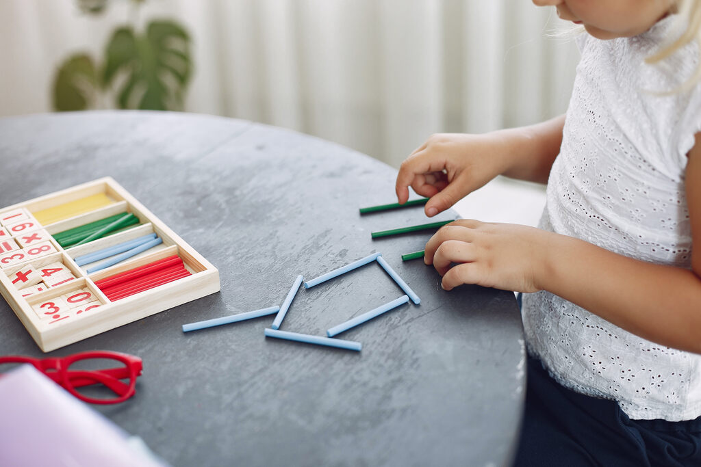 aluna aprendendo matemática para crianças com palitinhos