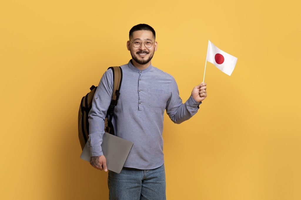 Jovem segurando bandeira do Japão