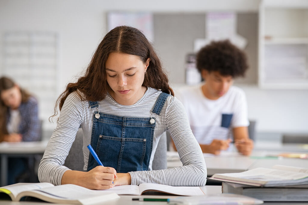 Aluna focada nos estudos em sala de aula, aplicando dicas de como escrever uma redação bem estruturada.